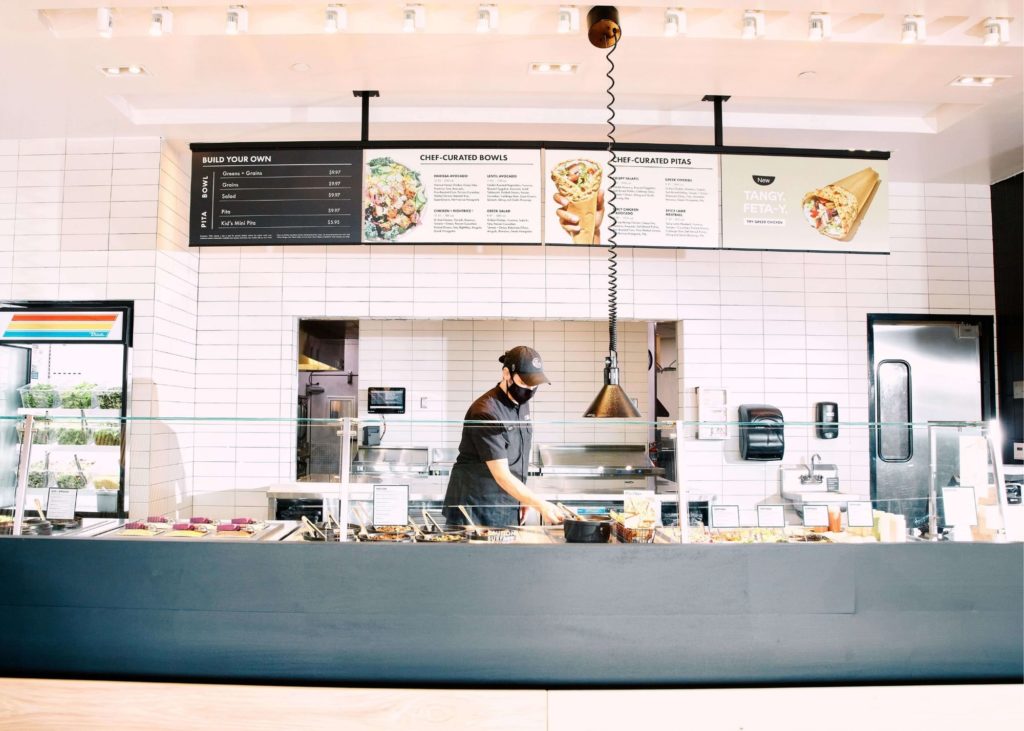 a man behind the counter preparing a meal