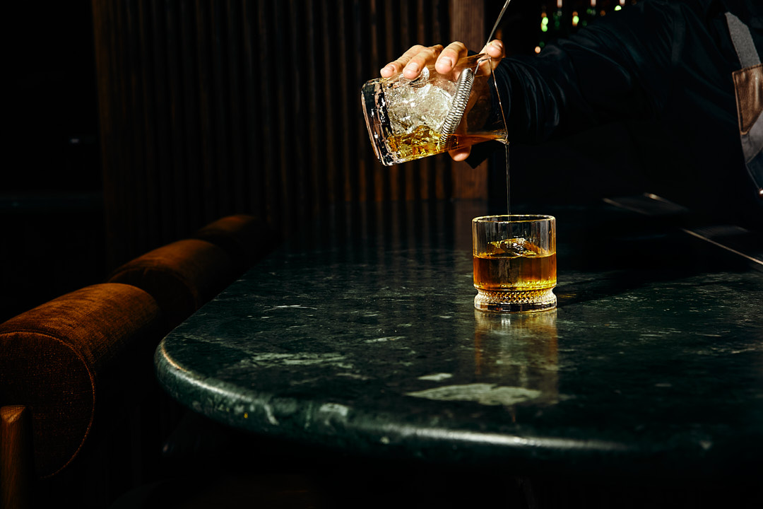 Foxtail Bar photography cocktail pour shot with moody lighting