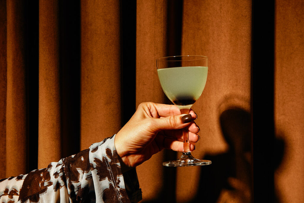 Foxtail Bar photography hand holding cocktail with dramatic lighting