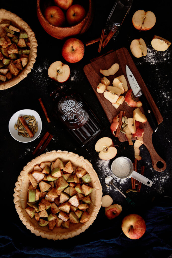 Flat lay of an Apple Pie with ingredients spread around.